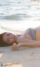 A woman laying on the beach in a bikini.