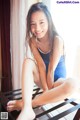 A woman in a blue bathing suit sitting on a chair.