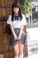 A young woman in a school uniform posing for a picture.